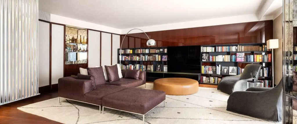 Wohnbereich der Suite mit eleganter Couchecke und großer Bücherwand