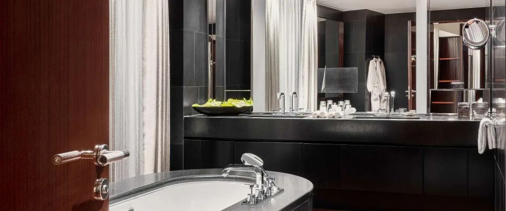 Modernes Badezimmer der Suite mit stilvollem Waschbecken und Dekoration
