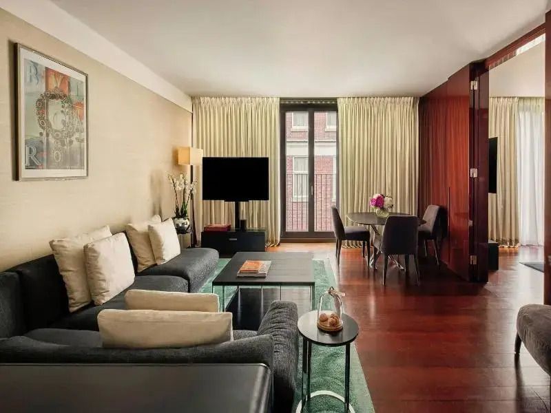 Elegantes Wohnzimmer mit Esstisch und großen Fenstern