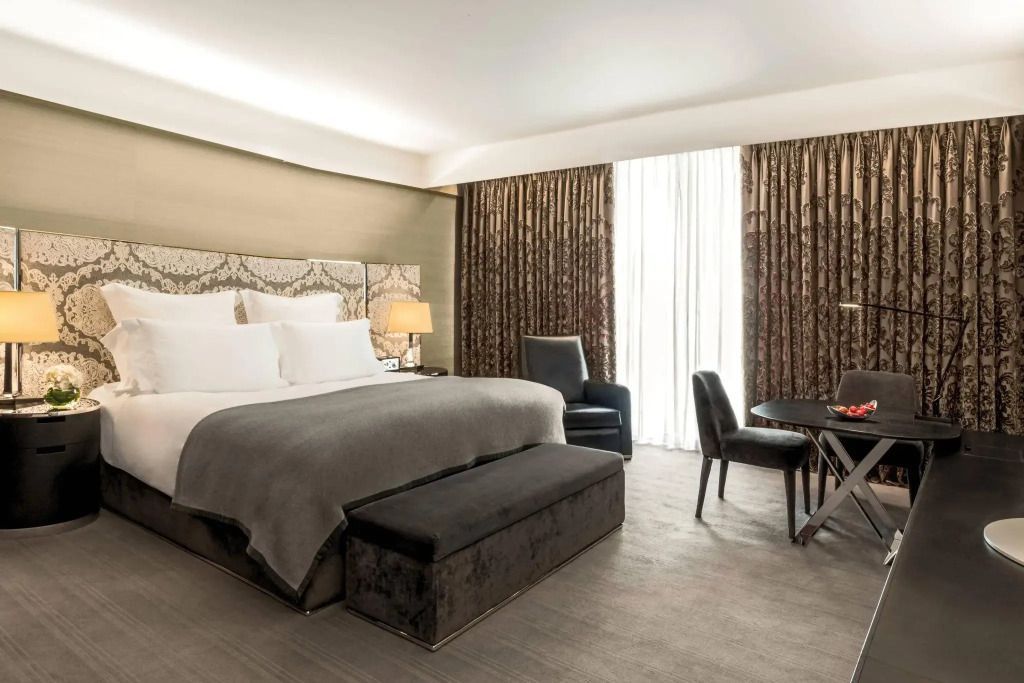 Elegantes Deluxe Zimmer mit Kingsize-Bett, Sesseln und Schreibtisch im Bvlgari Hotel London