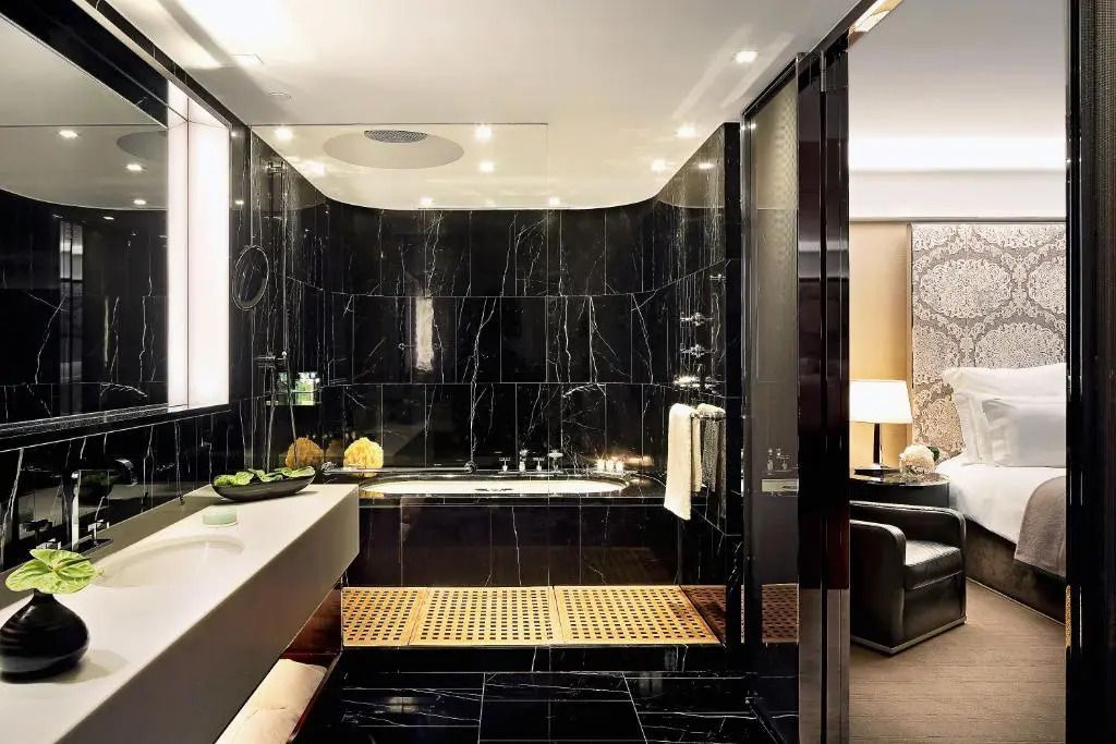 Luxuriöses Badezimmer mit dunklen Marmorelementen und entspannender Badewanne
