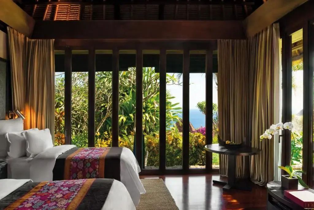 Elegantes Schlafzimmer einer Bvlgari Villa mit zwei Betten und Blick auf Garten und Meer