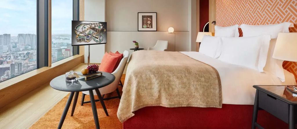 Modern eingerichtetes Schlafzimmer mit Kunstwerken und Dekor in erdigen Tönen