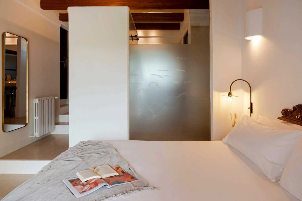 Modernes Schlafzimmer mit dezenter Beleuchtung und Glasabtrennung