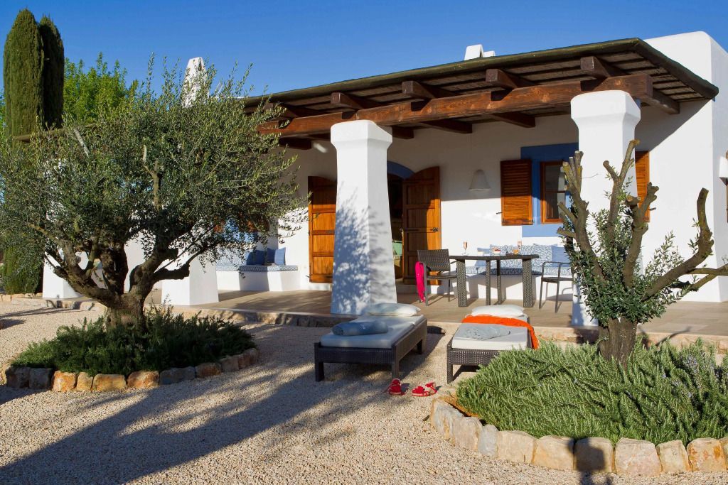 Einladende Terrasse mit Liegestühlen und Esstisch vor einem Zimmer im mediterranen Stil
