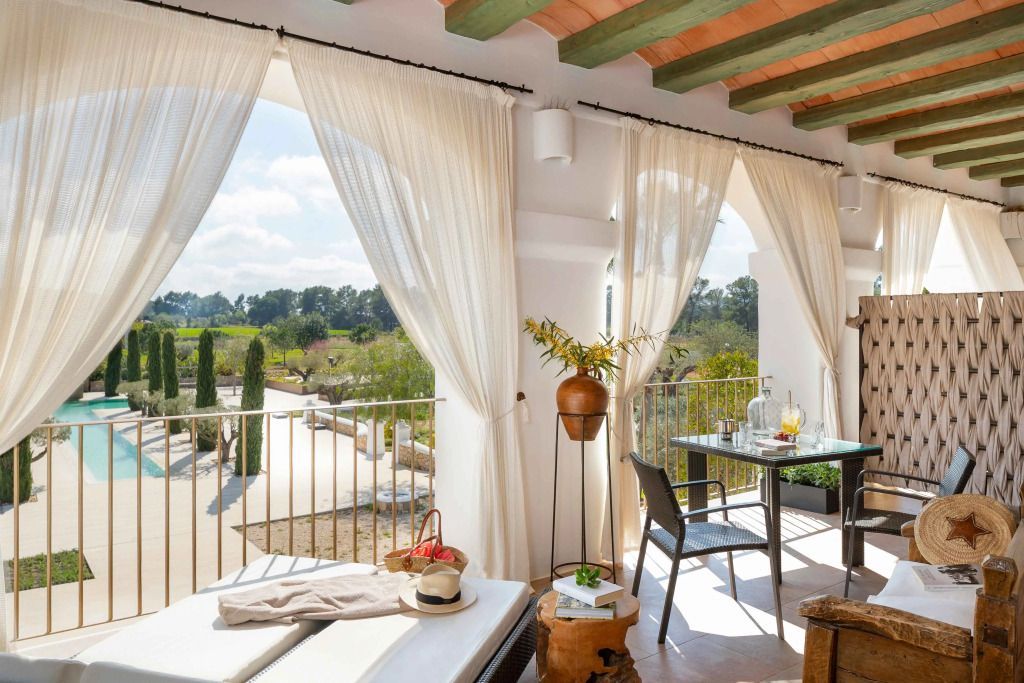 Hübscher Balkon mit Tisch und Liegen mit Blick auf die grüne Landschaft