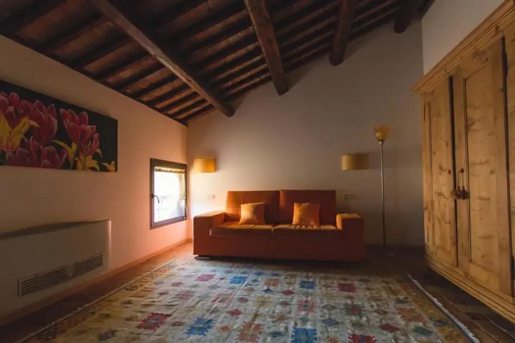 Sitzecke mit Sofa und farbenfrohem Teppich in einer Junior-Suite