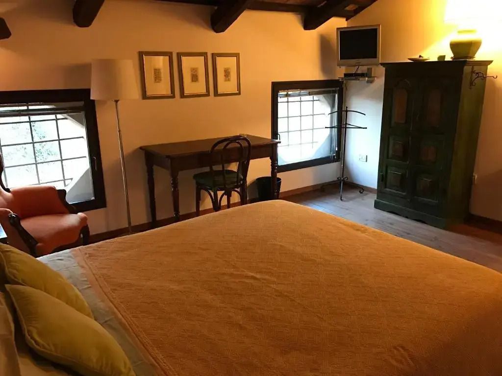 Standard Doppelzimmer mit Schreibtisch, Fernseher und Holzbalkendecke im Ca' Sagredo Hotel.