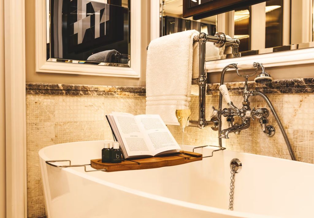 Luxuriöses Badezimmer mit freistehender Badewanne und Buchablage