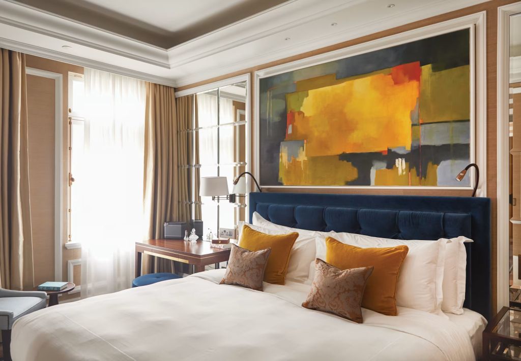 Luxuriöses Schlafzimmer mit Doppelbett und moderner Kunst an der Wand