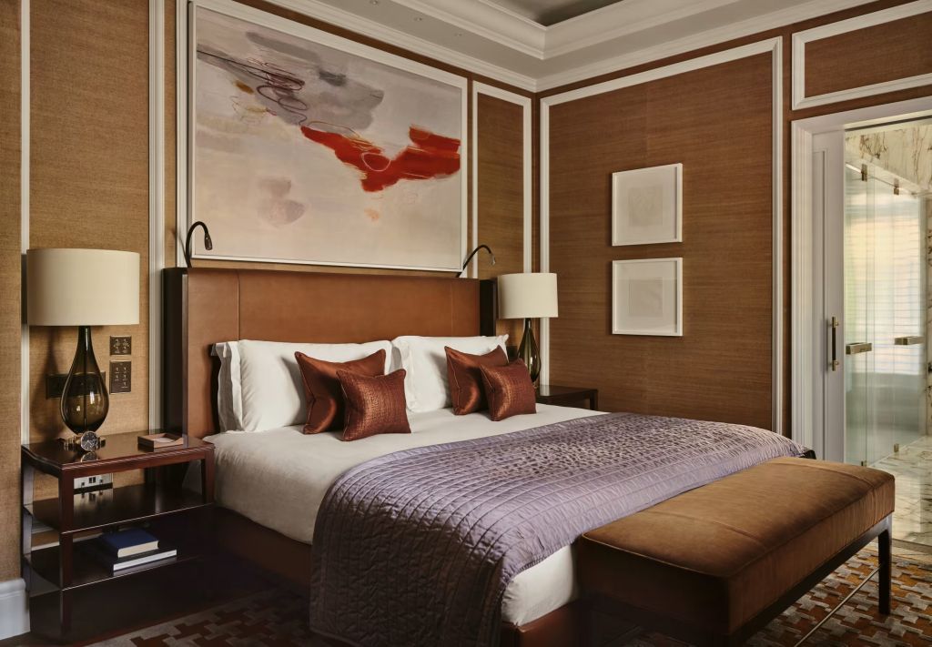 Luxuriöses Schlafzimmer mit Kingsize-Bett, dekorativen Kissen und moderner Kunst an der Wand