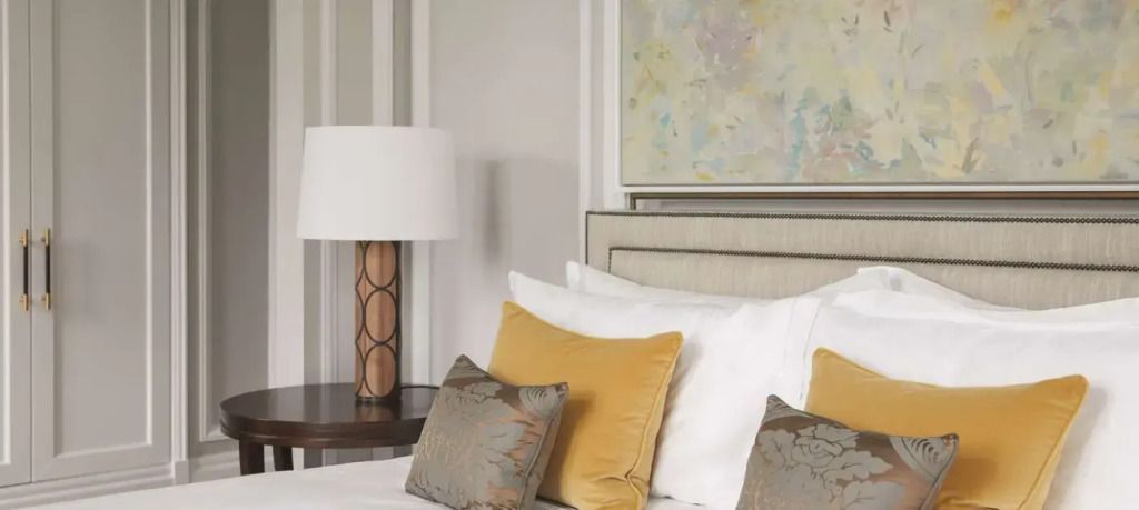 Elegantes Hotelzimmer mit stilvollen Kissen und Kunstwerk über dem Bett