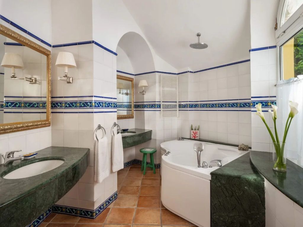 Geräumiges Badezimmer mit whirlpoolartiger Badewanne und eleganten Fliesen