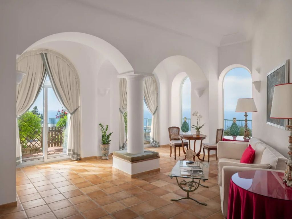 Helles Wohnzimmer mit großen Fenstern und Balkon mit Meerblick
