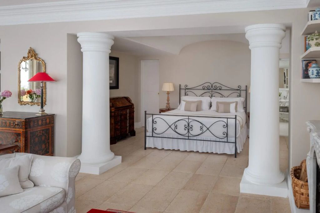 Elegante Schlafsuite mit Doppelbett in klassischem Design und Säulen