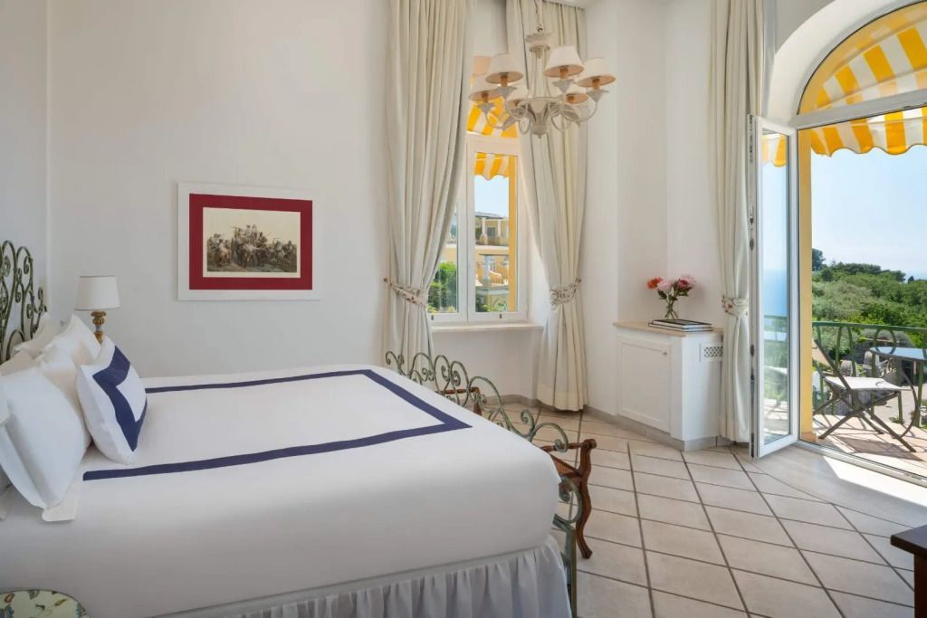 Helles Gästezimmer mit stilvollem Dekor und Blick durch Fenster.