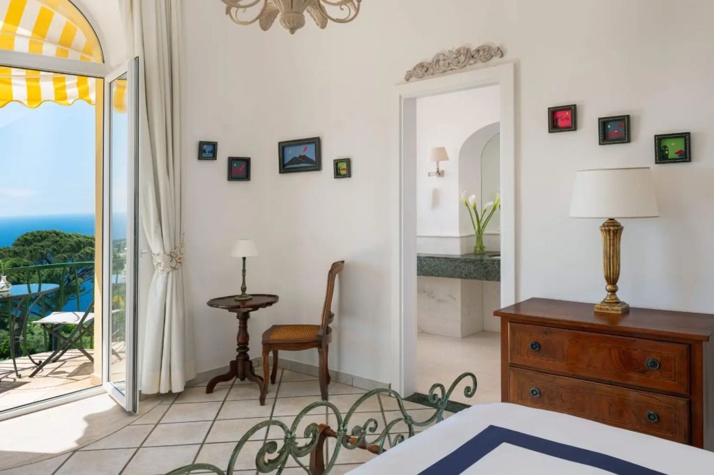 Helles Zimmer mit Zugang zu einem Badezimmer und eleganten Möbeln.