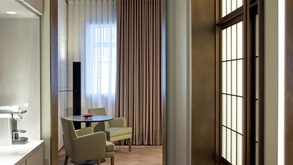 Kleiner Essbereich im Hotelzimmer mit Tisch und zwei Stühlen