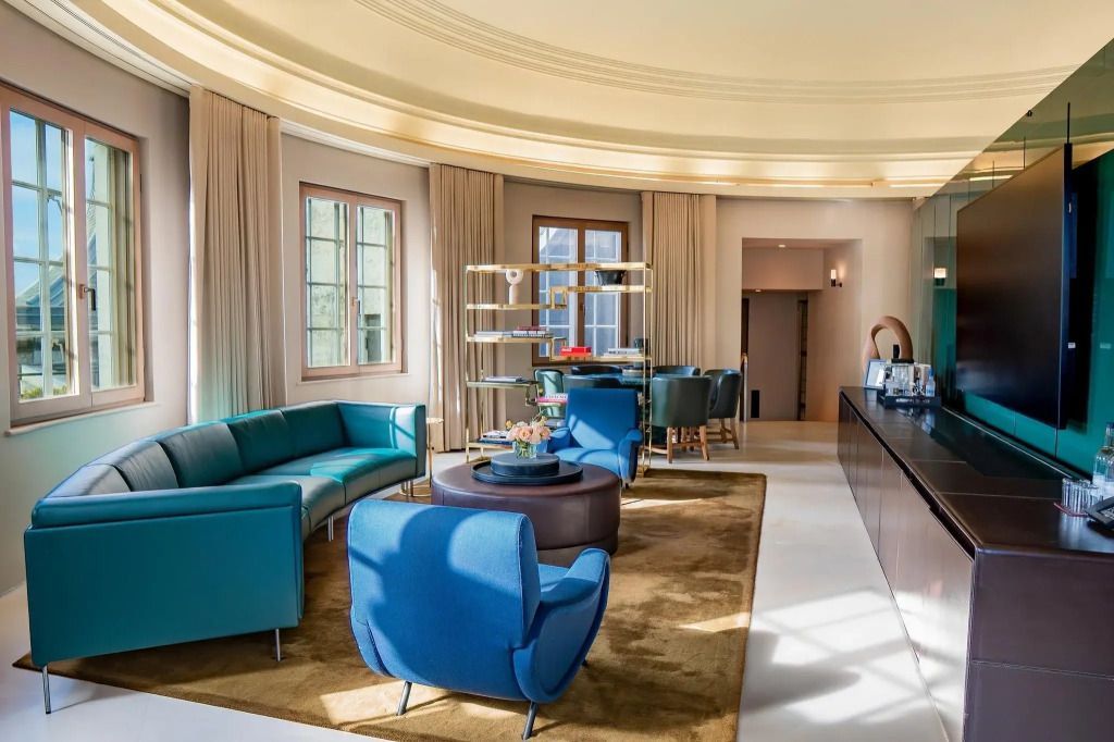 Großer Wohnbereich mit blauen Sofas und runder Decke im Dome Penthouse