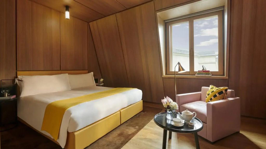 Elegantes Schlafzimmer mit Doppelbett und großem Fenster mit Holzwänden