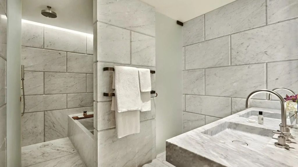 Modernes Badezimmer mit hochwertigen Steinfliesen und klaren Linien