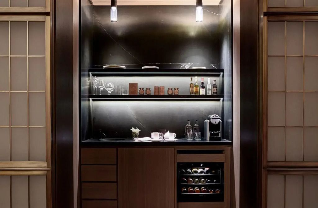 Moderne Minibar mit beleuchteten Regalen und Auswahl an Spirituosen in der Oscar Doppel Suite