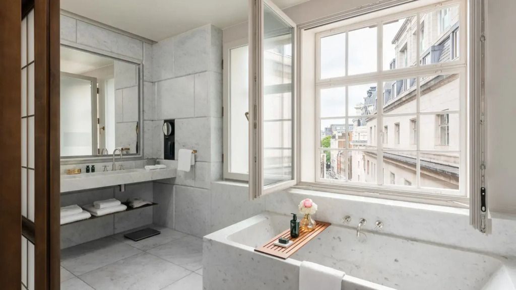 Luxuriöses Badezimmer mit Marmorwänden und großen Fenstern in der Oscar Doppel Suite
