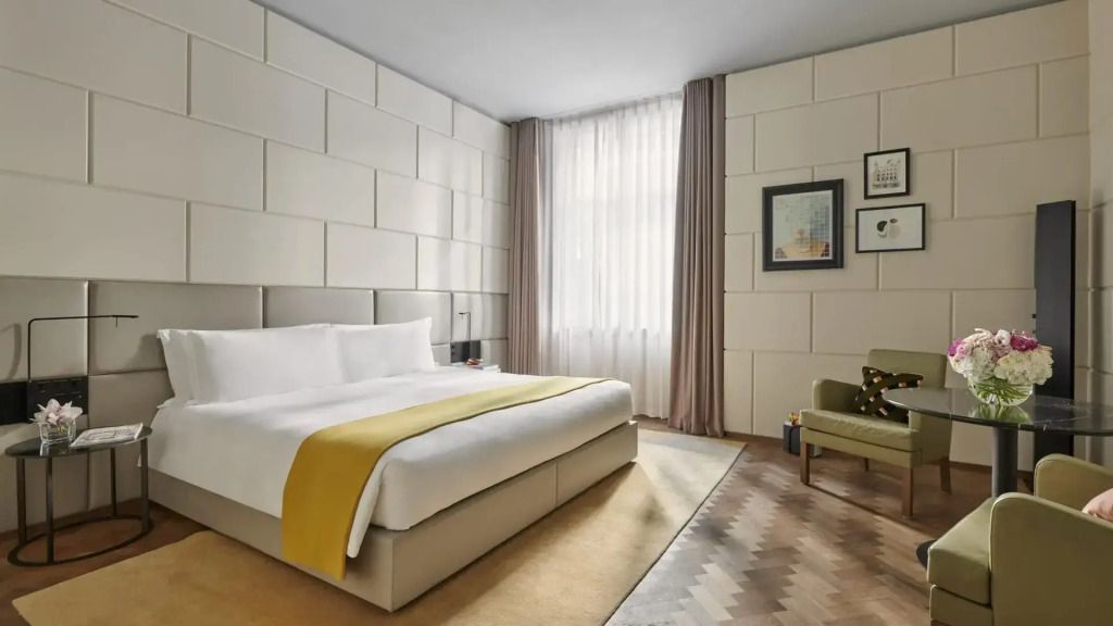 Komfortables Bett in modernem Zimmer mit eleganter Einrichtung und Kunstwerken