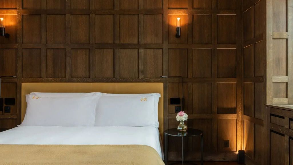 Detailansicht des Bettes in der Tudor Suite mit Holzvertäfelung und Nachttisch