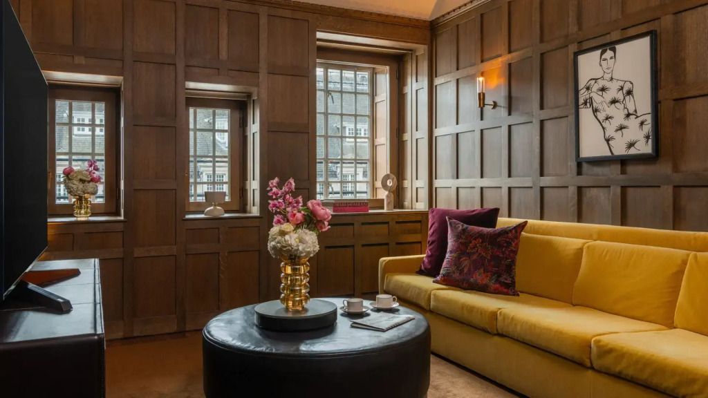 Loungebereich der Tudor Suite mit gelbem Sofa und Blumendekoration