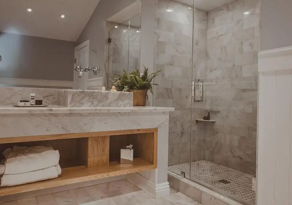 Luxuriöses Badezimmer mit Marmorwaschtisch und moderner Dusche in der Suite.