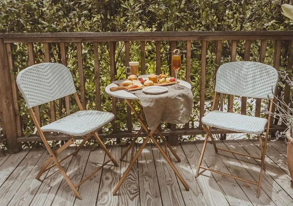 Gemütliche Terrasse mit Tisch und Stühlen, umgeben von üppigem Grün im Resort.