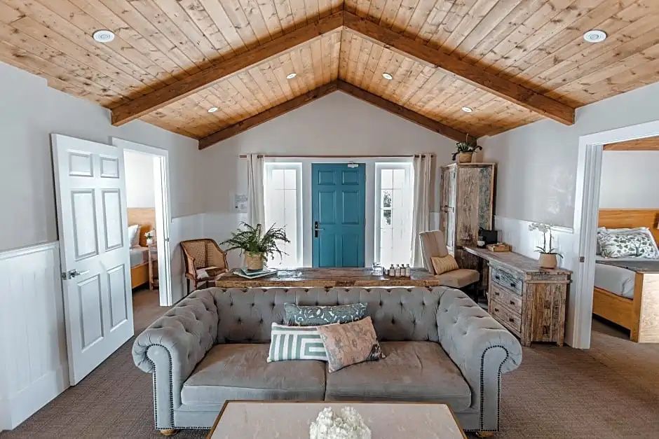Gemütliches Wohnzimmer mit straahlender Holzbalkendecke im Bungalow