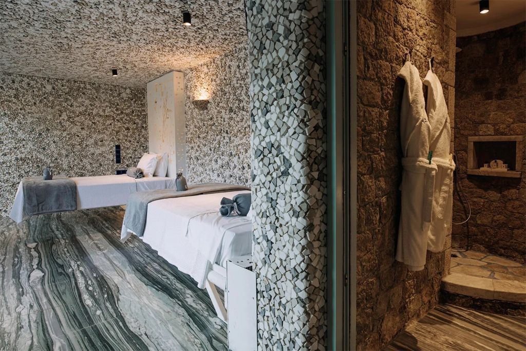 Schlafzimmer mit Naturstein- und Marmordekor und gemütlichen Bademänteln