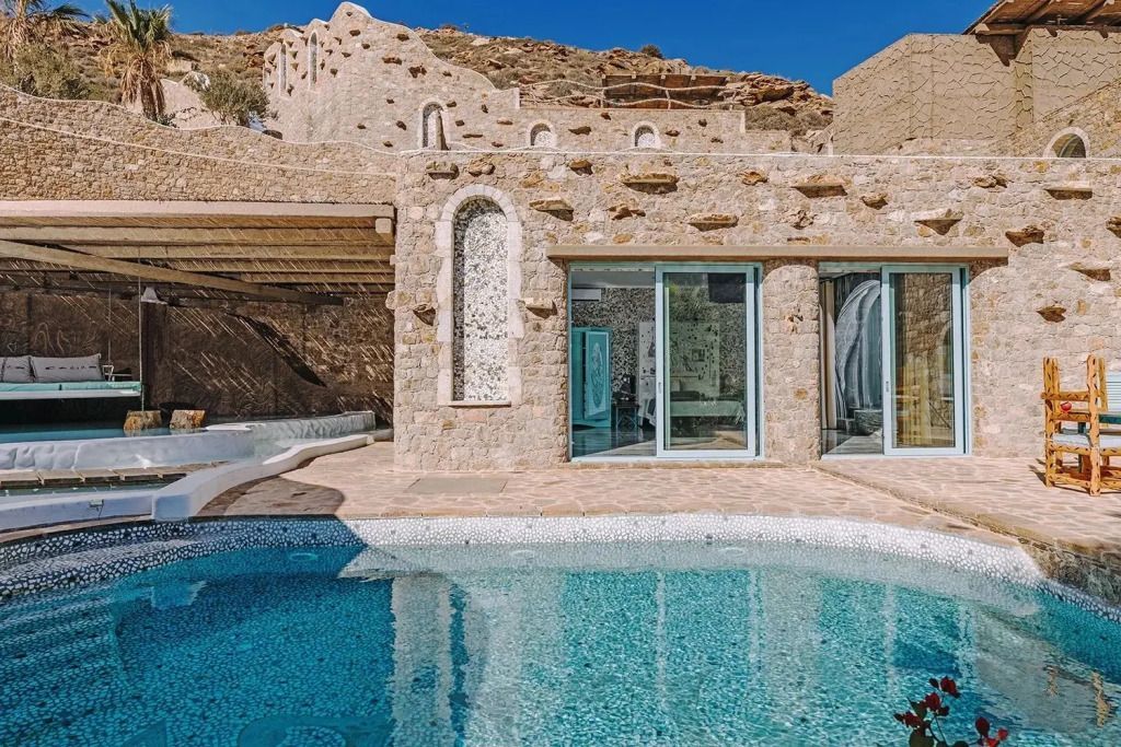 Außenansicht der Suite mit Pool und traditioneller Steinarchitektur.
