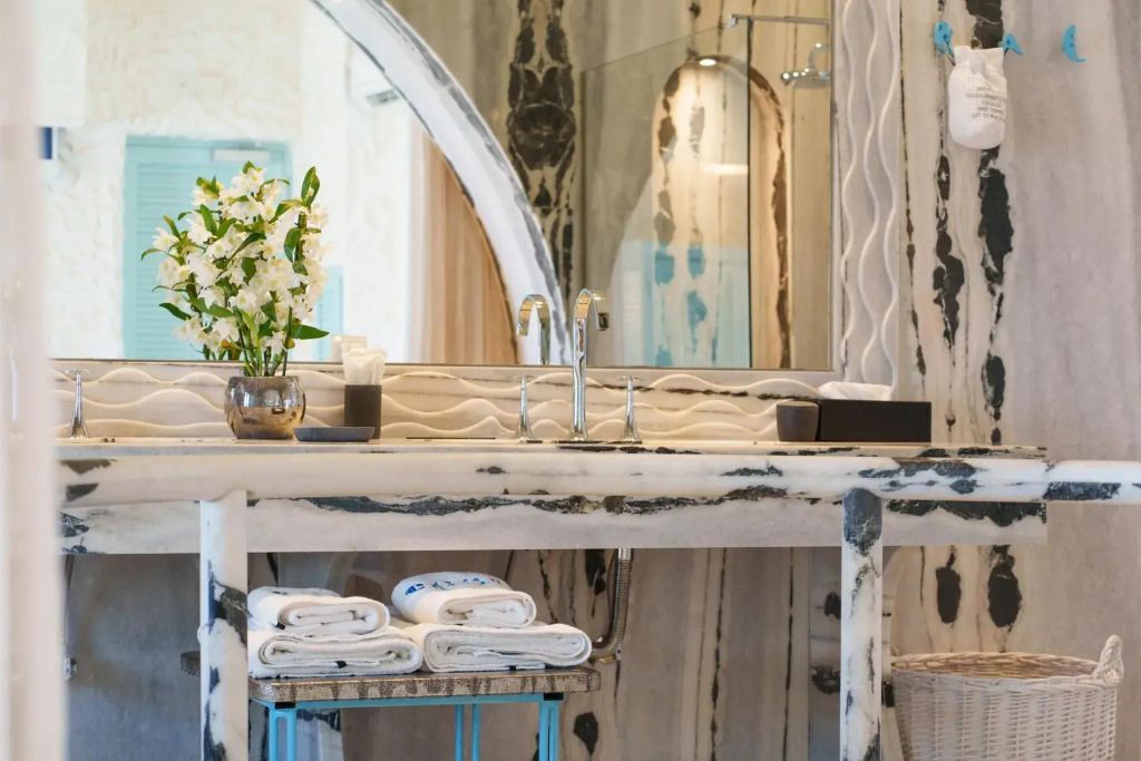 Detailansicht eines luxuriösen Badezimmerwaschtischs mit Blumenarrangement