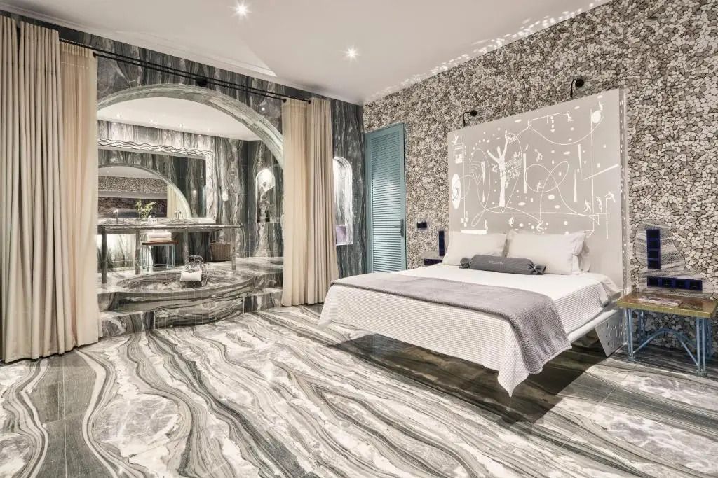 Luxuriöses Schlafzimmer mit Doppelbett, modernen Marmordetails und stimmungsvoller Beleuchtung