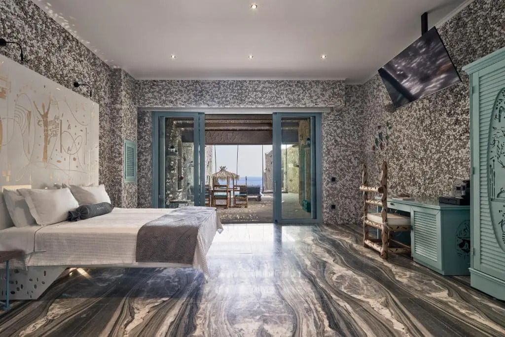 Suite mit Meerblick durch große Fenster, stilvolle Einrichtung und Zugang zur Terrasse