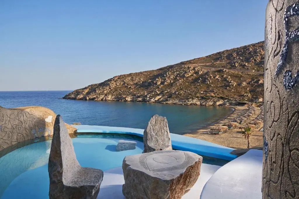 Panoramablick auf die Küste und das Meer von einer Terrasse mit skulpturalen Steinsitzen aus