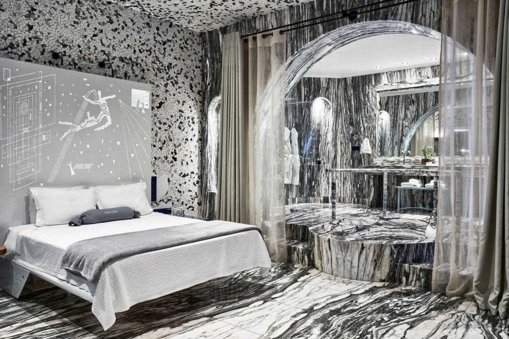 Luxuriöse Suite mit marmoriertem Interieur und Betten in der Everly Suite.