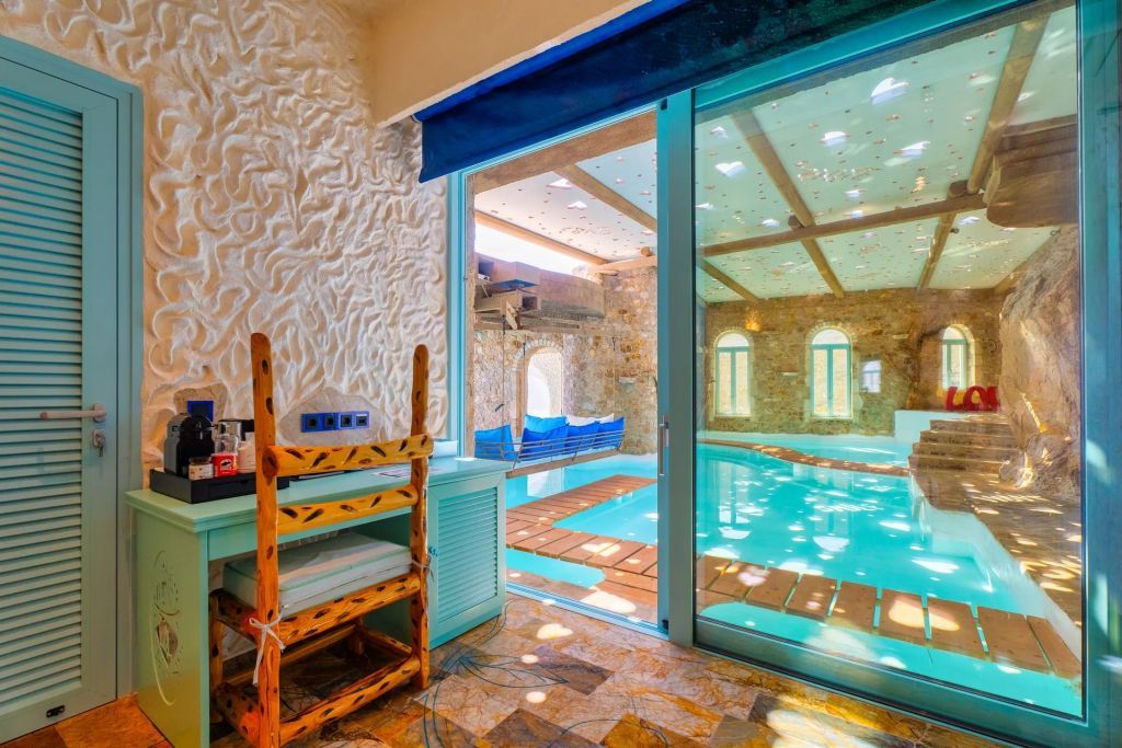 Zimmeransicht mit Blick auf den Pool durch große Glasfenster