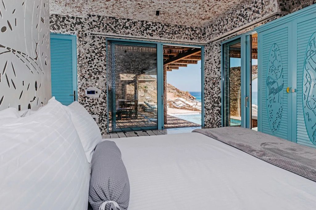 Hotelzimmer mit Blick auf die Terrasse und das Meer durch Glastüren