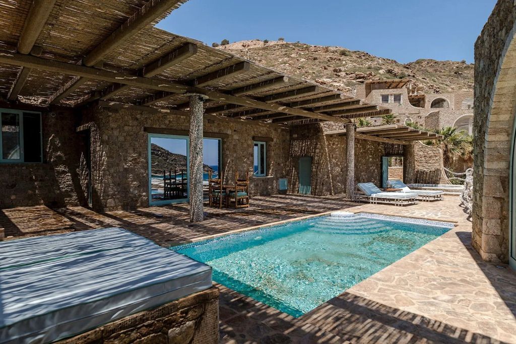 Privater Pool auf der Terrasse mit Sonnenliegen und Steinhäusern im Hintergrund