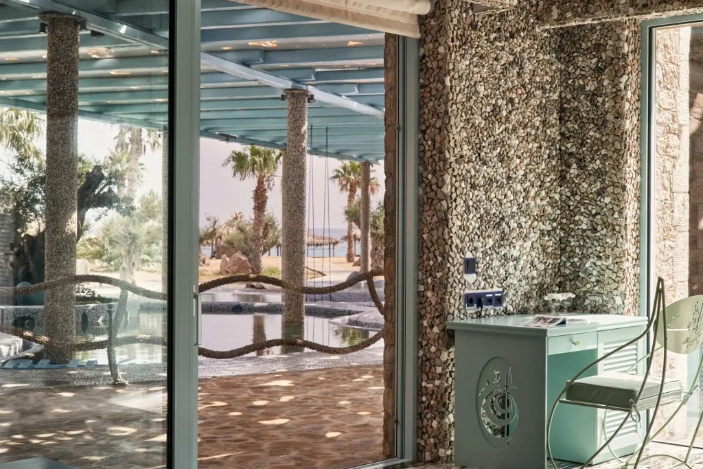 Ausblick auf Terrassenbereich mit Palmen durch große Fensterfront