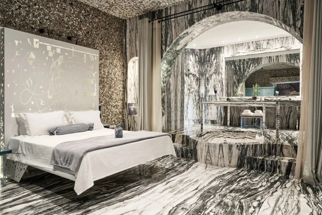 Luxuriöse Suite mit Marmorverkleidung und Doppelbett in einem eleganten Hotelzimmer