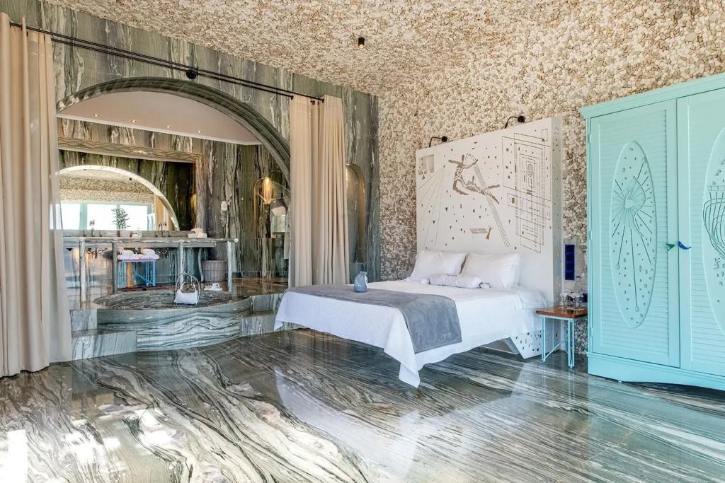 Luxuriöses Schlafzimmer der Panoramic Smiles Suite mit elegantem Marmor und Kunstwerk