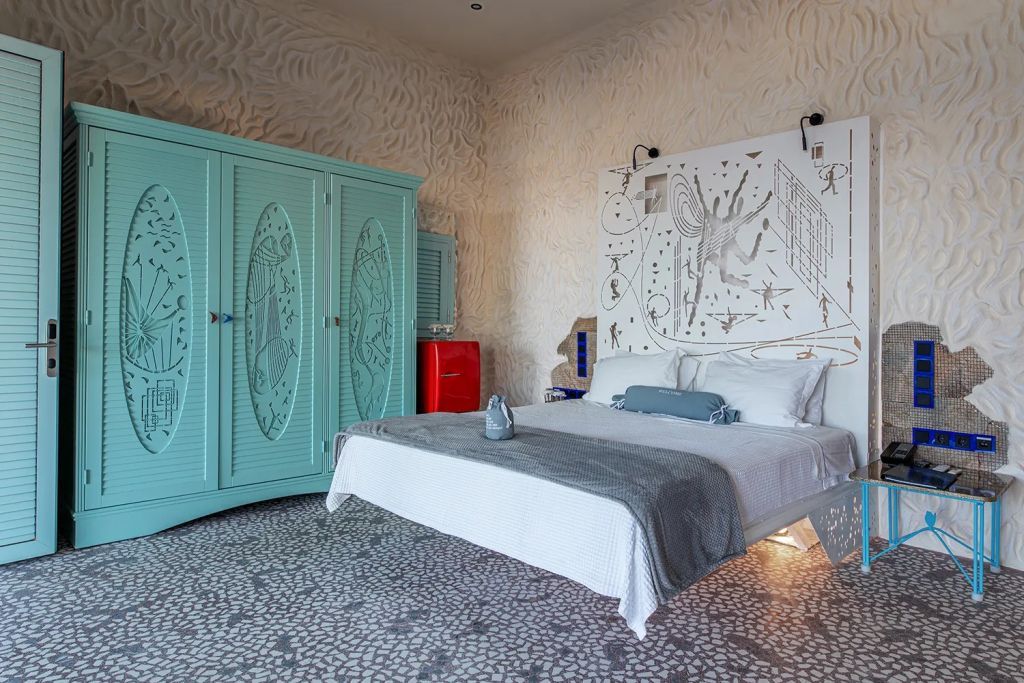 Geschmackvoll eingerichtetes Schlafzimmer mit auffälligem türkisfarbenem Schrank