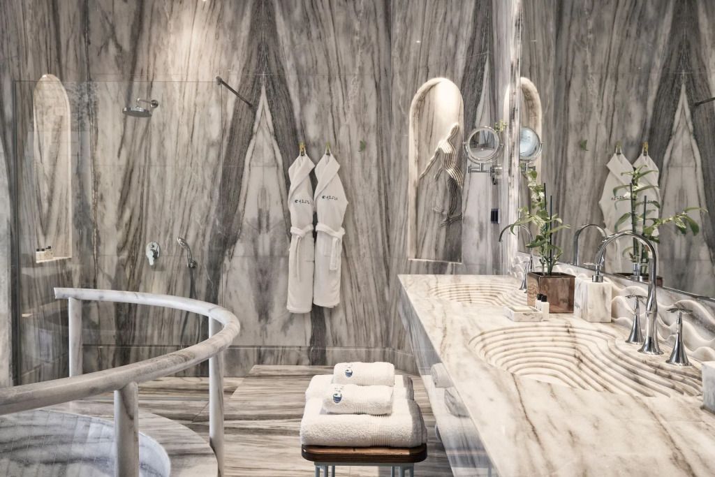 Marmorgeprägtes Badezimmer mit eleganten Badmänteln und Pflegeartikeln