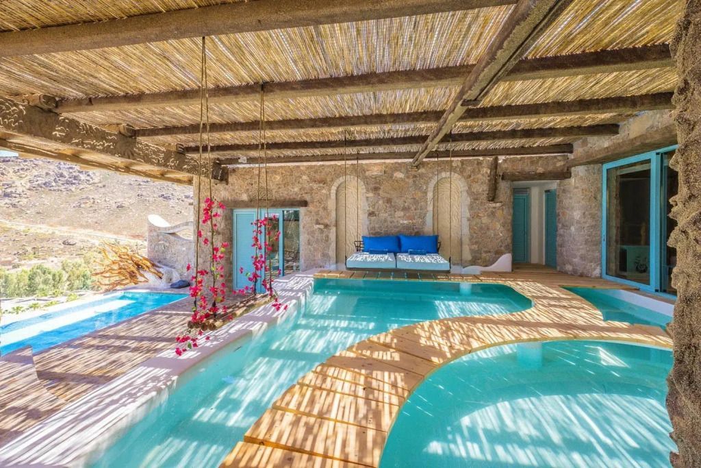 Sonnendurchflutete Terrasse mit Pools und Liegen in der Suite
