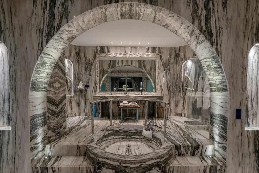 Luxuriöses Badezimmer mit Marmordekor und einem großen Spiegel.